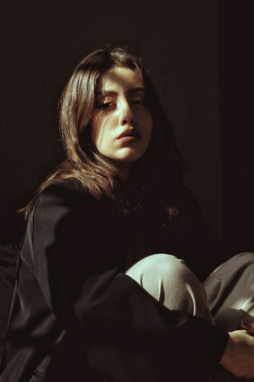 Studio portrait of a woman with shoulder-length brown hair in a dark blazer